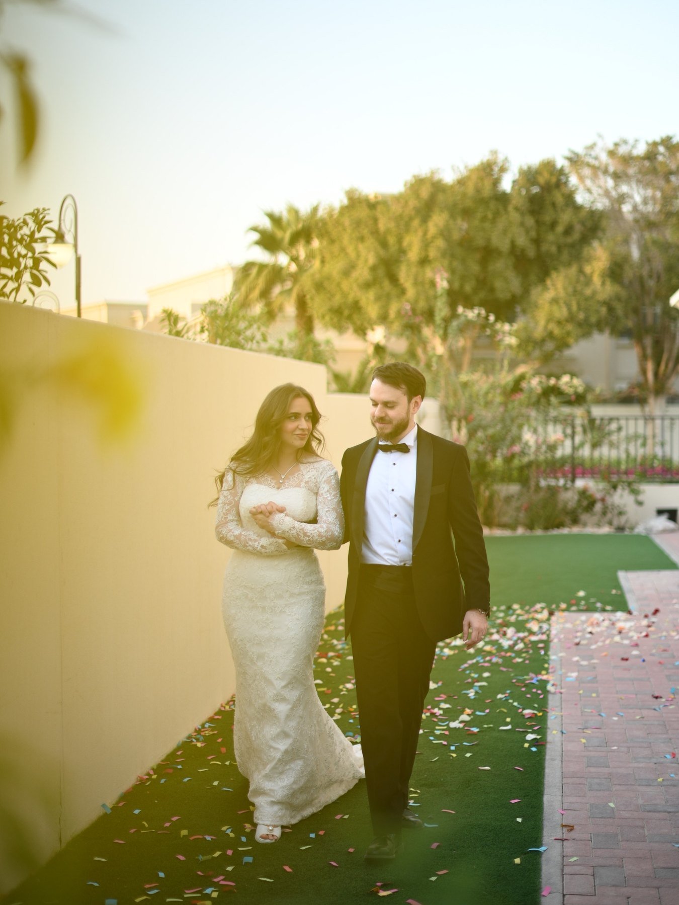 Couple embracing on a green lawn at golden hour